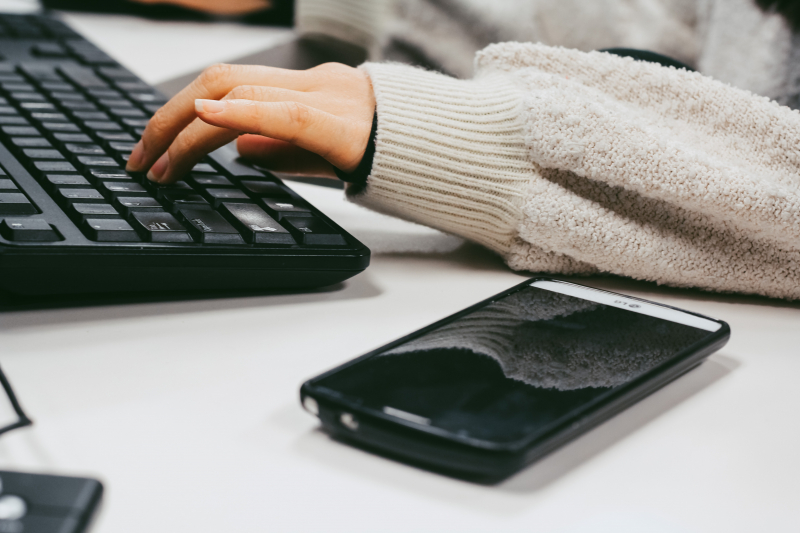 Persona escribiendo en el teclado de un ordenador